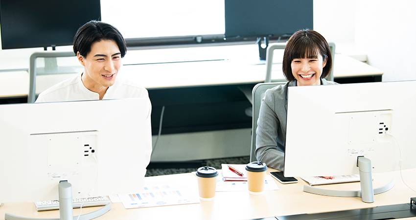 笑顔でPC操作する男女
